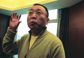 11月27日，重庆，李庄接受潇湘晨报记者采访，说到激动处用手不停比划。　图/记者倪志刚