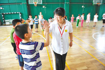 北京安定医院儿科每年都会定期去小学进行心理拓展活动，图为在西城区德胜社区学校组织的主题为“让孩子心里充满阳光”的大型活动，心理康复治疗师与孩子们游戏互动。