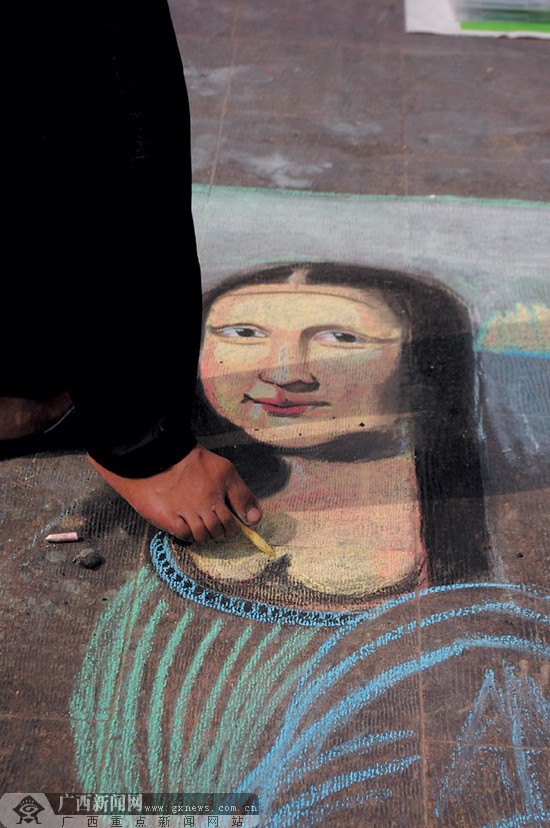 程义用脚趾头夹住一根粉笔，熟练地在地上画出蒙娜丽莎。