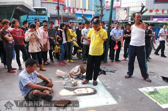  3名残疾人在街头卖艺吸引人群捧场，从左至右分别是宋群、程义和邱举。