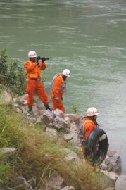 8日上午，消防官兵在江边搜寻失踪者。