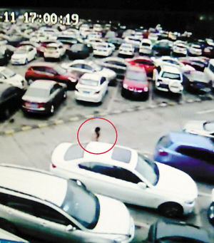 　　■女子（红圈处）站在宝马车旁，用锐器从车位到车头划出一道印痕。