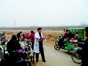 家庭医生深入村头宣传健康教育,接受村民咨询。